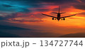 Silhouette of Airplane Flying at Sunset with Dramatic Horizon Colors 134727744
