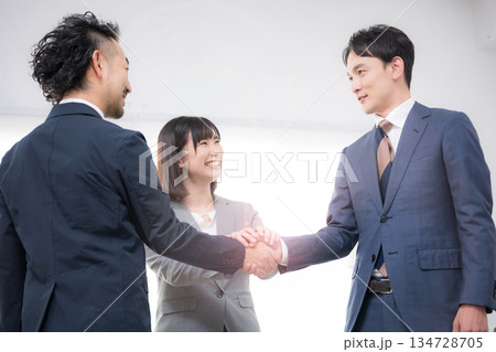 握手をするビジネスマン3人の契約、m＆a、協業や協力イメージ 134728705