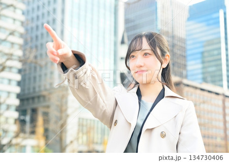 オフィス街で指差しをする女性 オフィス街で指差しをする女性 134730406