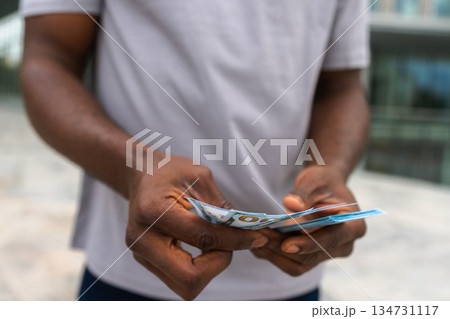Man hands holding money dollar bills on urban street outdoor. Businessman hands counting currency money outdoors near office bank building. Unrecognizable man holding cash. Finance economy banking Man hands holding money dollar bills on urban street outdoor. Businessman hands counting currency money outdoors near office bank building. Unrecognizable man holding cash. Finance economy banking 134731117