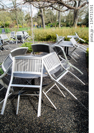 イスが斜めにテーブルにかけられた開店前のカフェのテラス　ロンドン郊外のキューガーデンにて 134731591