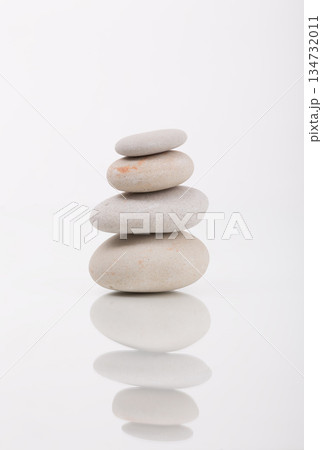 Stacked Balanced Spa Stones on White Reflective Surface 134732011