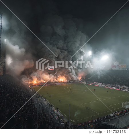 発煙と熱狂的な観客に包まれたサッカースタジアムの試合風景 134732158