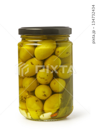 Green pickled olives in jar with herbs 134732434