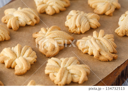 Homemade butter spritz cookies baking on parchment paper Homemade butter spritz cookies baking on parchment paper 134732513
