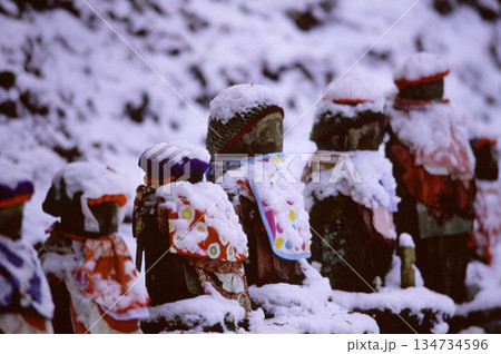 雪をかぶって並ぶお地蔵さん 134734596