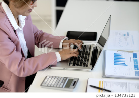 Business woman 50+ years old executive level  typing on a laptop keyboard 134735123