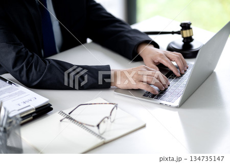 On the desk of a lawyer working with a notebook is working on documents to prepare for a lawsuit 134735147