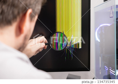 Person examining a broken computer monitor with a magnifying glass showing dead pixels and cracks, symbolizing technology repair, hardware failure, or IT service 134735345