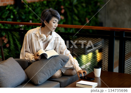 elder 50+ woman sitting relax read book on sofa i elder 50+ woman sitting relax read book on sofa i 134735696