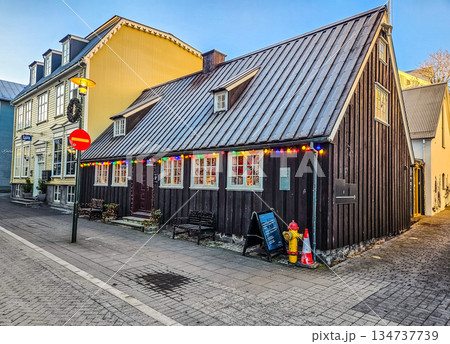 Traditional Wooden House with Christmas Lights in Winter City Traditional Wooden House with Christmas Lights in Winter City 134737739