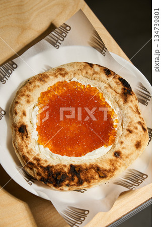 Wooden Plate With Glossy Salmon Topping, Artistic Shot Capturing Fresh Salmon Roe And Toasted Crust 134739801