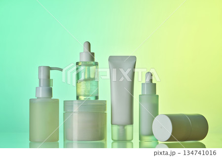 Skincare cosmetic products standing against gradient background Skincare cosmetic products standing against gradient background 134741016