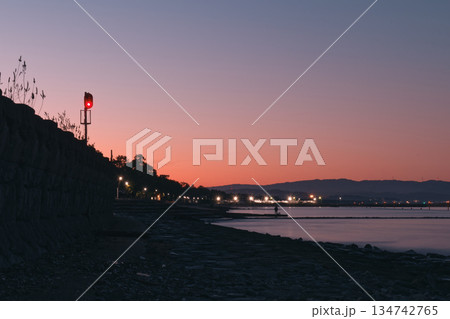 夕暮れ時の能登半島のあかりとローカル線の信号機 134742765