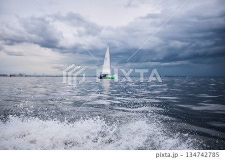splashing water from under the rubber boat in stormy weather, sailing regatta in the Gulf of Finland in heavily rain 134742785