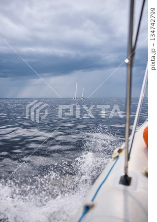 splashing water from under the rubber boat in stormy weather, sailing regatta in the Gulf of Finland in heavily rain 134742799
