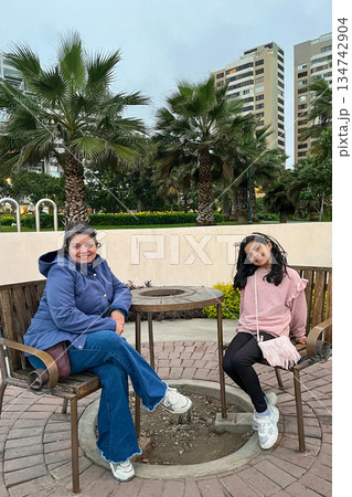 Mother and daughter is sitting at a table in a park 134742904