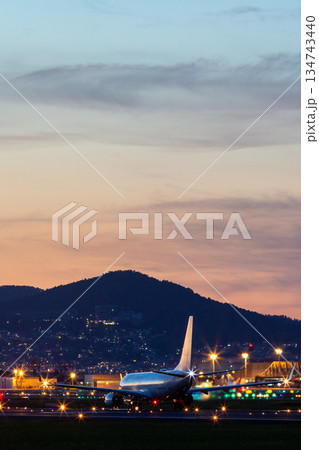 夕焼けの滑走路｜飛行機｜夕空｜縦 134743440