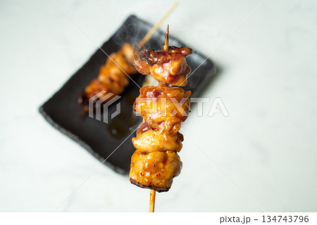 たれ味の焼き鳥を食べる 134743796