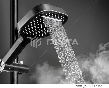 Shower head with running water in dark bathroom 134745462