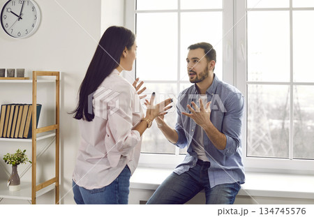 Young family couple having a disagreement, quarreling, and shouting at each other Young family couple having a disagreement, quarreling, and shouting at each other 134745576