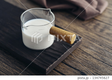 Milk in measuring glass cup Milk in measuring glass cup 134745627