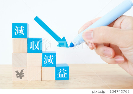 減収減益を示す下向き矢印と日本円の概念イメージ。 減収減益を示す下向き矢印と日本円の概念イメージ。 134745765