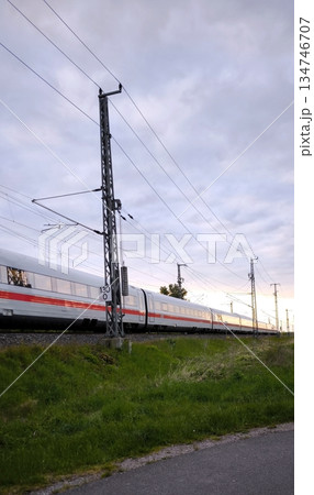 A high-speed ICE train rushes past a contact line support A high-speed ICE train rushes past a contact line support 134746707