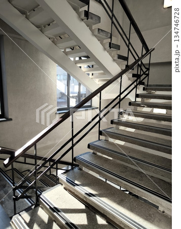 Concrete staircase with metal railings and contrasting steps in a modern building 134746728