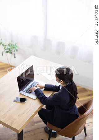 パソコンで作業するスーツを着た女性の後ろ姿 134747380