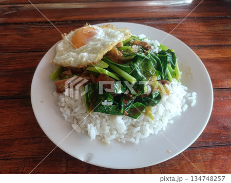 Stir fried pork fried egg jasmine rice thai food basil leaf asian cuisine stirred together creating tasty street style meal Stir fried pork fried egg jasmine rice thai food basil leaf asian cuisine stirred together creating tasty street style meal 134748257