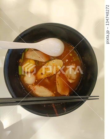Spicy noodle soup bowl fish ball sausage chopstick spoon asian food hot delicious comfort meal Spicy noodle soup bowl fish ball sausage chopstick spoon asian food hot delicious comfort meal 134748272