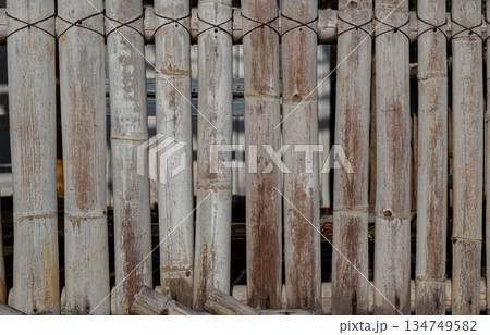 Weathered bamboo fence showing natural texture, knots, and muted color palette ideal for rustic design backdrops and eco-friendly themed projects 134749582