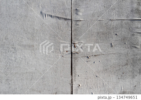 Weathered gray wooden planks showing age and texture for rustic backgrounds and distressed designs adding vintage character Weathered gray wooden planks showing age and texture for rustic backgrounds and distressed designs adding vintage character 134749651