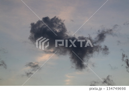Dark cloud formation in blue sky at dusk creating dramatic atmosphere, perfect for weather forecasts and atmospheric backgrounds Dark cloud formation in blue sky at dusk creating dramatic atmosphere, perfect for weather forecasts and atmospheric backgrounds 134749698
