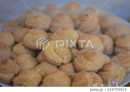 Pile of Cream Puffs Displaying Golden Crust under Natural Light with Soft Focus, perfect for patisserie promotions Pile of Cream Puffs Displaying Golden Crust under Natural Light with Soft Focus, perfect for patisserie promotions 134750015