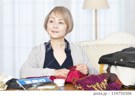 リビングで旅行の荷造りをするシニア女性 134750306