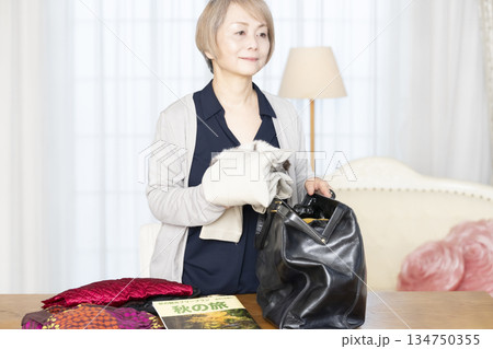 リビングで旅行の荷造りをするシニア女性 134750355