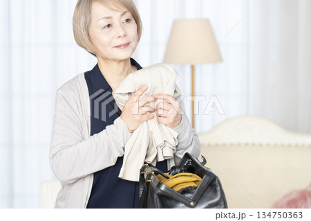 リビングで旅行の荷造りをするシニア女性 134750363