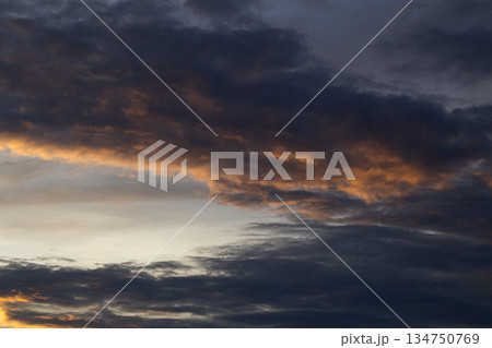 Dramatic sky with dark storm clouds and golden light creating ominous atmosphere for weather forecast background 134750769