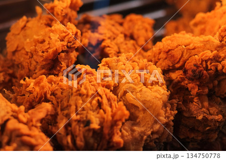 Delicious crispy fried chicken pieces arranged closely, showcasing golden brown texture and tempting snack appeal, for mouthwatering food concept 134750778