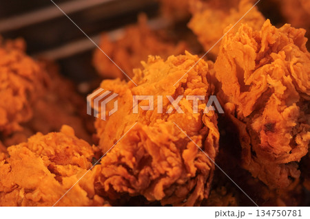 Delicious crispy fried chicken pieces arranged closely in a dark setting, showcasing a tempting texture and vibrant color for fast food promotions 134750781