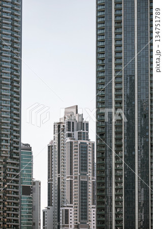 Tall skyscraper building dominates the skyline in a bustling urban city center Tall skyscraper building dominates the skyline in a bustling urban city center 134751789
