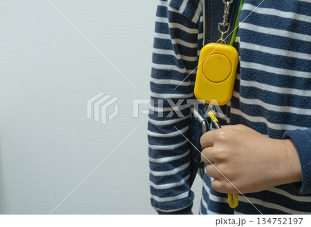 防犯ブザーを引こうとする子供の手 134752197