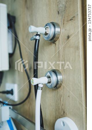 Discover stylish water connection fixtures that are elegantly mounted on a wooden wall, making them the perfect choice for enhancing modern interior design aesthetics in any contemporary space 134753737