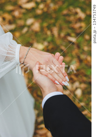 A Romantic Couples Hands Holding Each Other Warmly During Their Beautiful Autumn Wedding Ceremony A Romantic Couples Hands Holding Each Other Warmly During Their Beautiful Autumn Wedding Ceremony 134753749