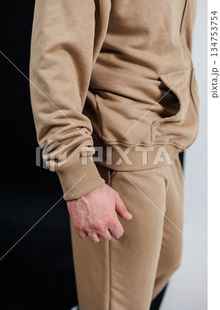 A detailed close up view of a person s arm wearing a tan sweater A detailed close up view of a person s arm wearing a tan sweater 134753754