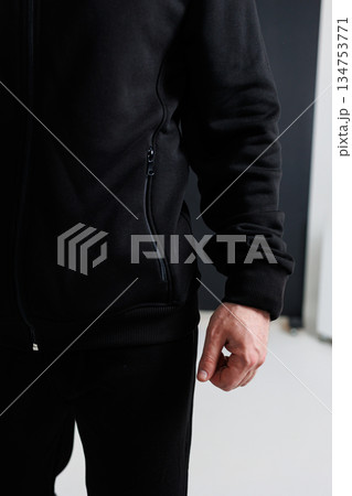 A man wears a stylish black jacket with a side zipper A man wears a stylish black jacket with a side zipper 134753771