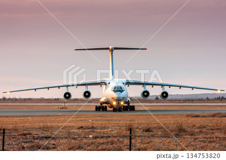 Front view of the big transport cargo airplane taxiing at airport taxiway in the evening light 134753820