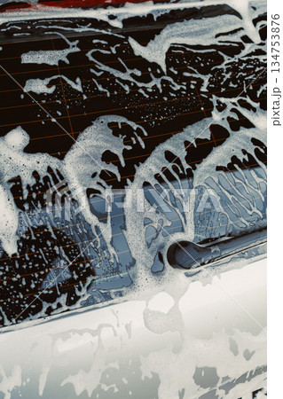 The process of car washing is currently underway, which involves creating a thick, foamy lather that efficiently cleans and enhances the cleanliness of the vehicles surface and overall appearance 134753876